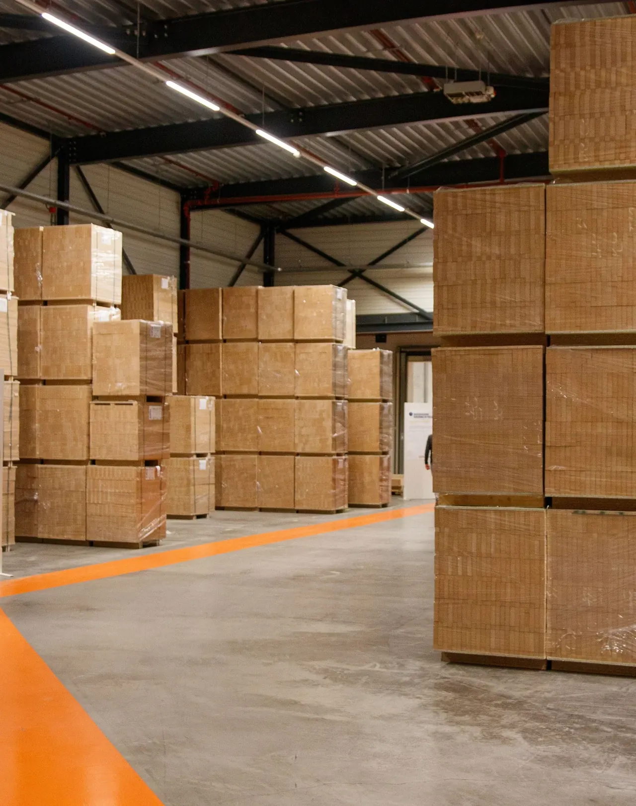 Warehouse with stacked cartons and an orange floor line